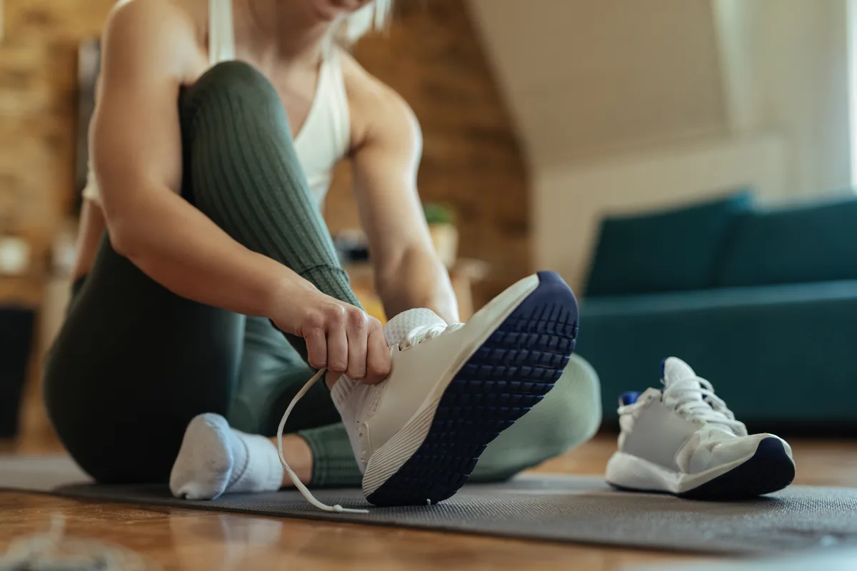 Un sportif enfile ses chaussures de sport pour une séance d’entraînement